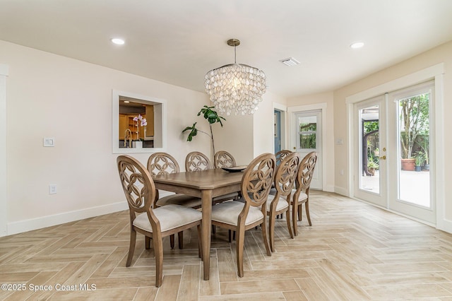 dining area with light parquet flooring, french doors, and an inviting chandelier