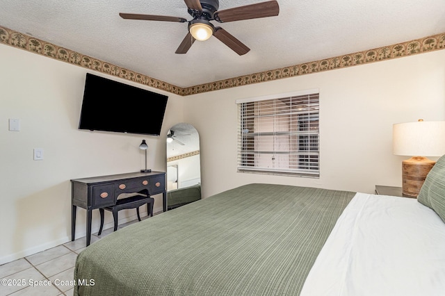 tiled bedroom featuring ceiling fan and a textured ceiling