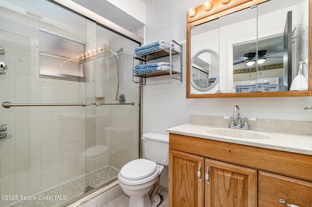 bathroom with a shower with shower door, ceiling fan, backsplash, tile walls, and vanity