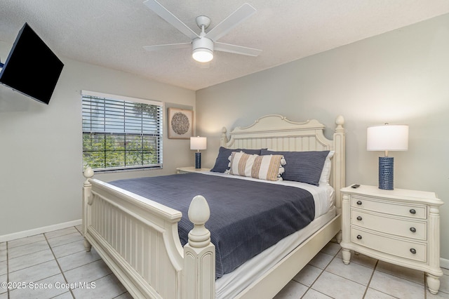 bedroom with a textured ceiling, ceiling fan, and light tile patterned flooring