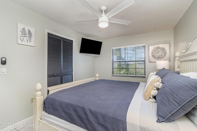 bedroom featuring ceiling fan, a textured ceiling, and a closet