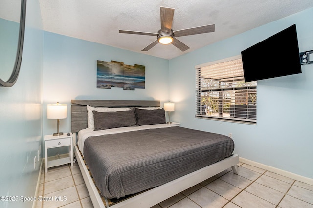 tiled bedroom with ceiling fan and a textured ceiling