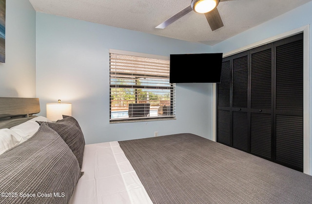 bedroom featuring a textured ceiling, ceiling fan, and a closet