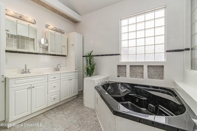 bathroom featuring vanity, tile walls, backsplash, and a relaxing tiled tub