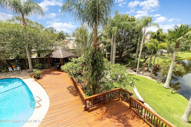 view of swimming pool featuring a deck with water view, a gazebo, and a lawn