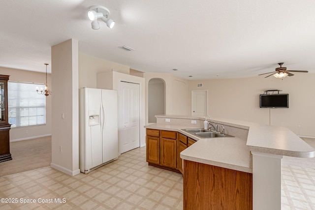 kitchen featuring ceiling fan, pendant lighting, sink, light carpet, and white fridge with ice dispenser