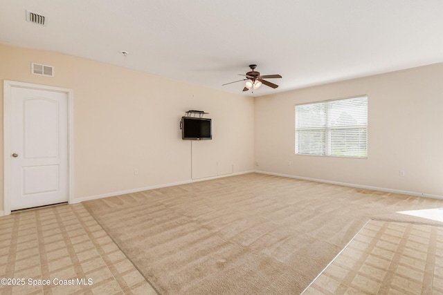 carpeted spare room featuring ceiling fan