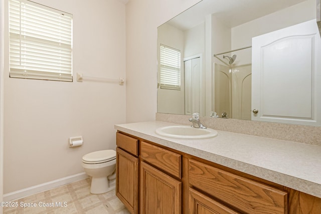 bathroom featuring toilet, walk in shower, and vanity