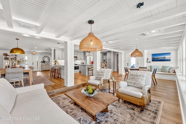 living room featuring light hardwood / wood-style floors and beamed ceiling