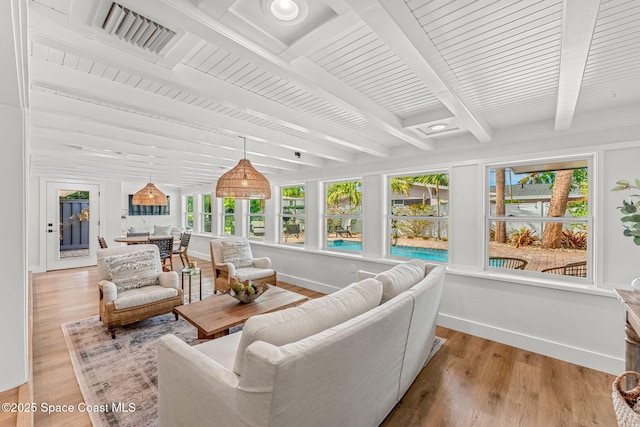 sunroom / solarium featuring beamed ceiling