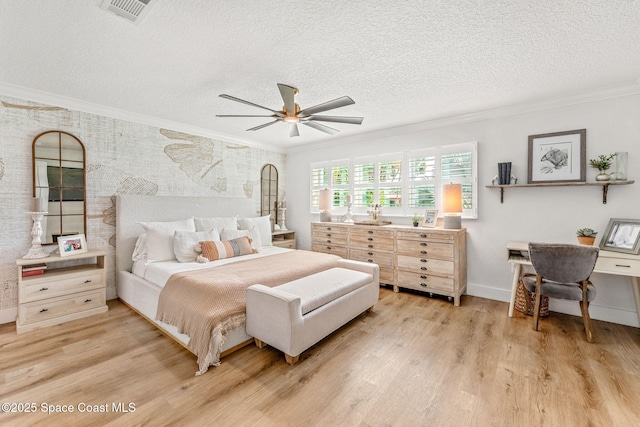 bedroom featuring ceiling fan, ornamental molding, a textured ceiling, and light wood-type flooring