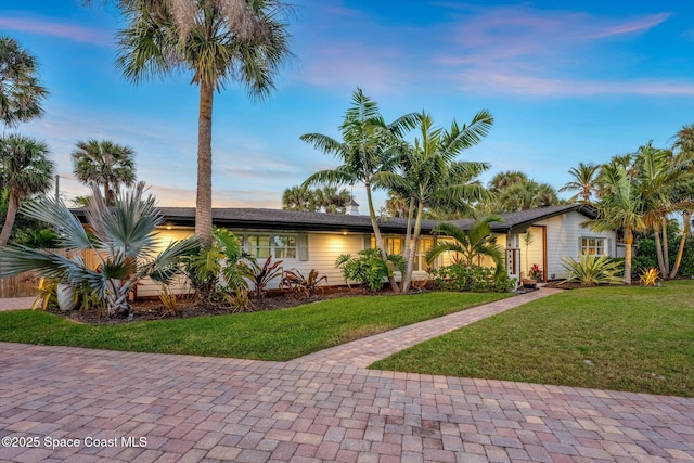 ranch-style home with a lawn