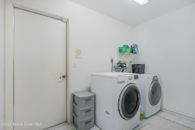 laundry room with light tile patterned floors and washing machine and clothes dryer