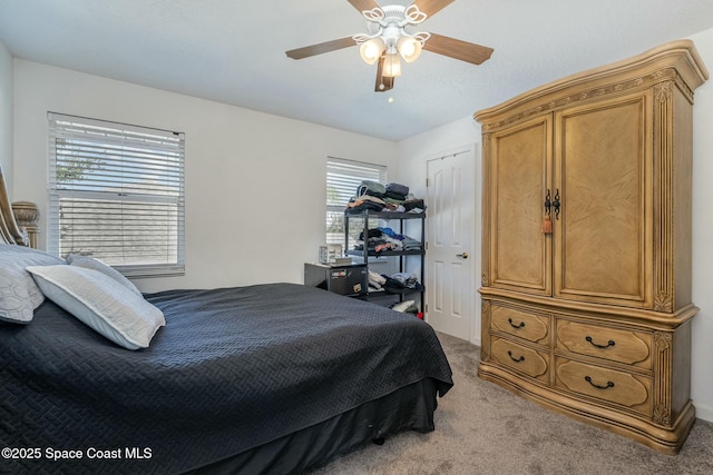 carpeted bedroom with ceiling fan and a closet