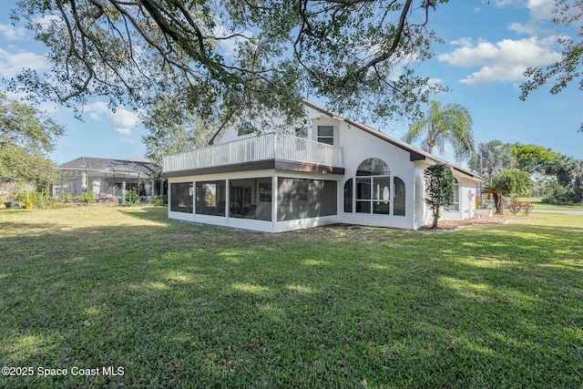 rear view of property with a yard and a sunroom