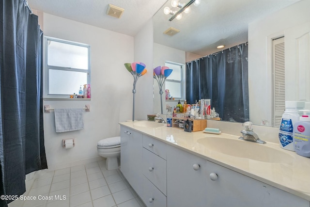 bathroom featuring tile patterned flooring, vanity, plenty of natural light, and a textured ceiling