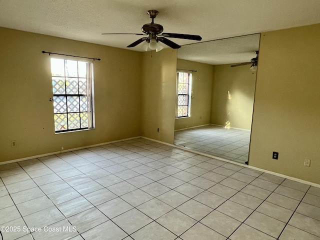 tiled spare room featuring ceiling fan and a textured ceiling