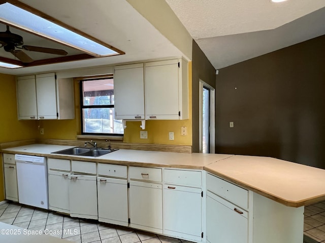 kitchen with sink, white dishwasher, white cabinets, vaulted ceiling, and kitchen peninsula