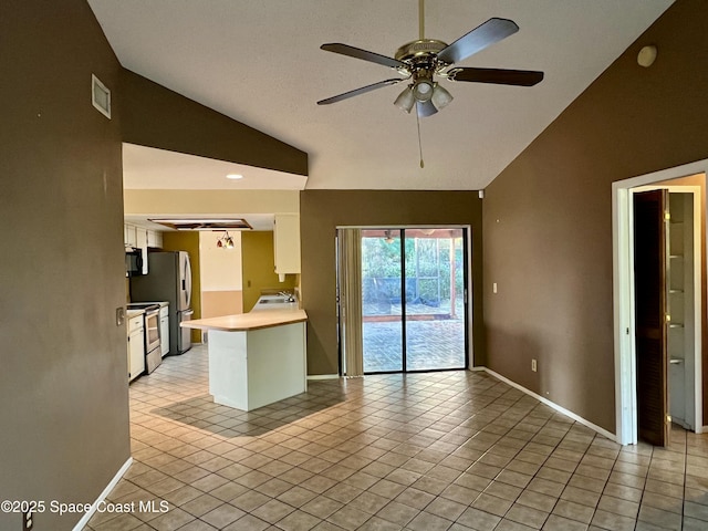 interior space with ceiling fan, lofted ceiling, washer / dryer, and light tile patterned floors