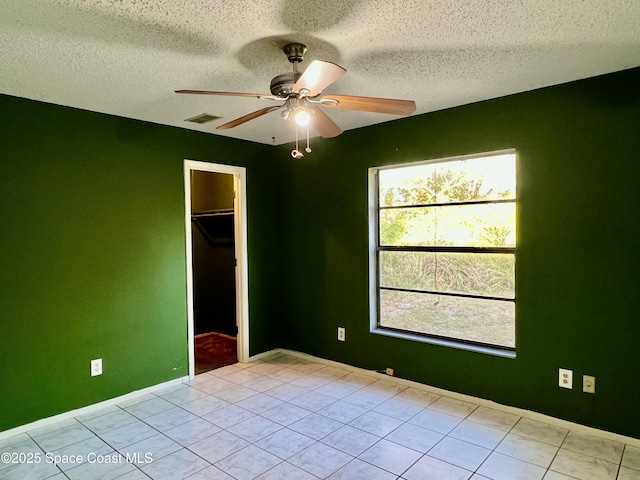 tiled spare room featuring ceiling fan and a textured ceiling