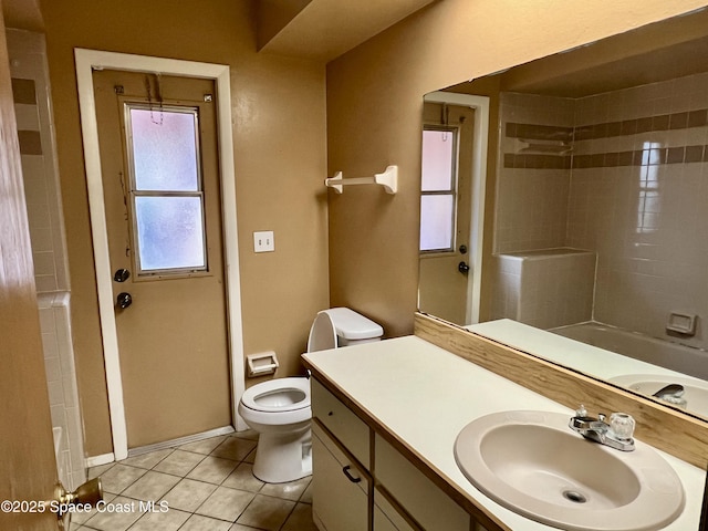 full bathroom with tile patterned flooring, tiled shower / bath, vanity, and toilet