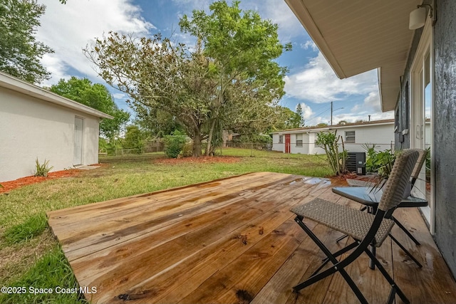 wooden terrace featuring central AC unit and a lawn