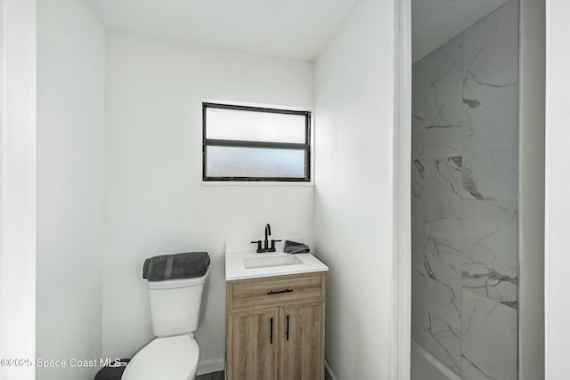 bathroom with toilet, vanity, and a tile shower