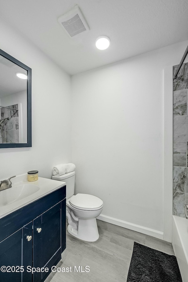 full bathroom with shower / bathing tub combination, hardwood / wood-style floors, toilet, and vanity