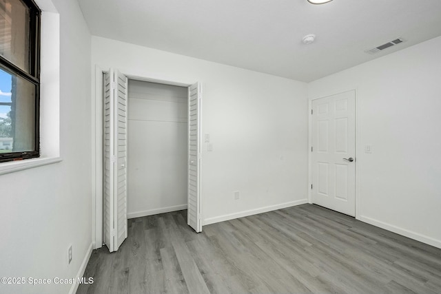 unfurnished bedroom featuring a closet and light wood-type flooring