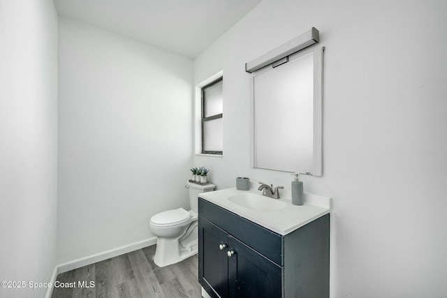 bathroom featuring wood-type flooring, toilet, and vanity