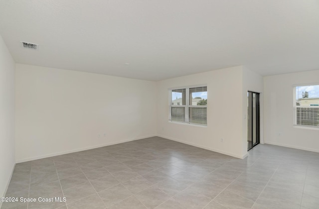 tiled empty room with a healthy amount of sunlight