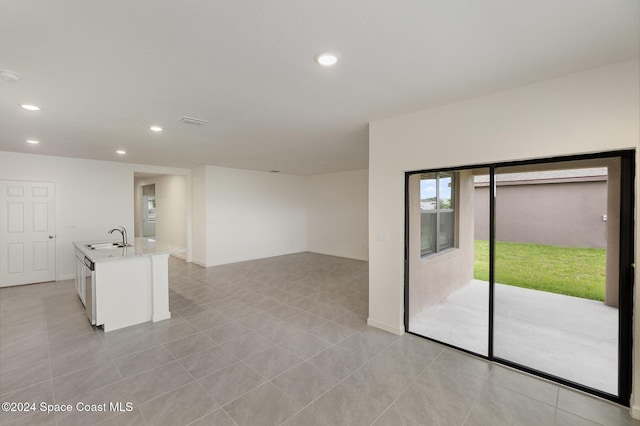 spare room featuring light tile patterned flooring and sink