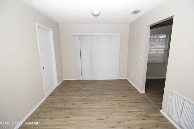 interior space featuring light hardwood / wood-style floors and a textured ceiling