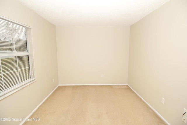 unfurnished room featuring light carpet