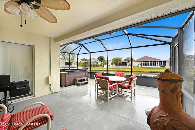 view of patio with glass enclosure and a hot tub