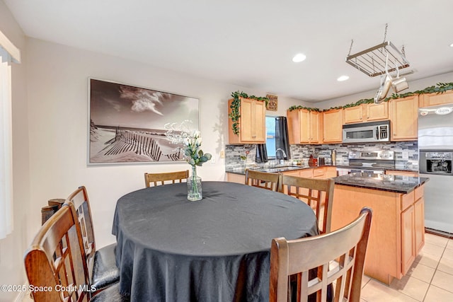 dining space featuring sink and light tile patterned floors