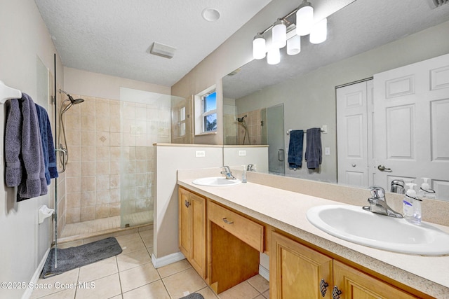 bathroom featuring walk in shower, a textured ceiling, tile patterned floors, and vanity