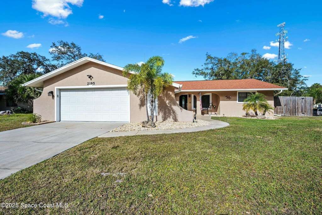 ranch-style home with a garage and a front lawn