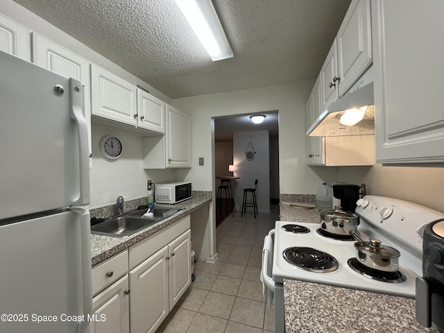 kitchen featuring sink, white appliances, white cabinetry, and light tile patterned flooring