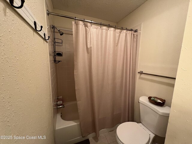 bathroom with a textured ceiling, toilet, tile patterned flooring, and shower / bath combo with shower curtain