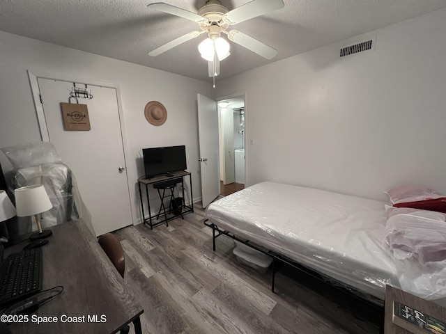 bedroom featuring ceiling fan, a textured ceiling, and hardwood / wood-style floors