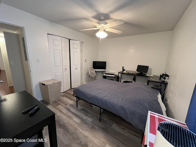 bedroom featuring ceiling fan, hardwood / wood-style floors, a closet, and a textured ceiling