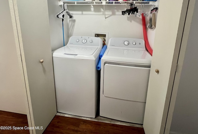 laundry room with dark hardwood / wood-style floors and washing machine and clothes dryer