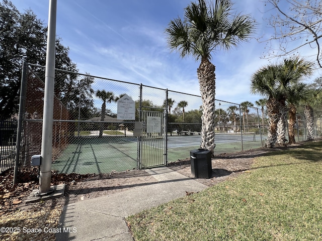 view of tennis court with a yard