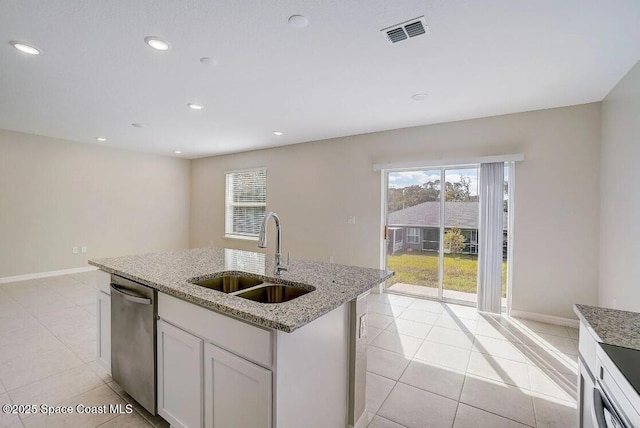 kitchen featuring stainless steel dishwasher, sink, a kitchen island with sink, white cabinets, and light stone counters