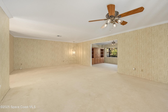 carpeted empty room with crown molding and ceiling fan