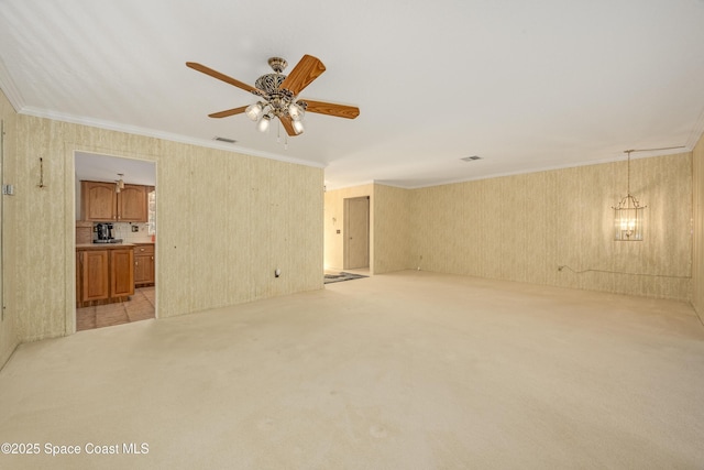 unfurnished living room featuring light carpet, crown molding, and ceiling fan