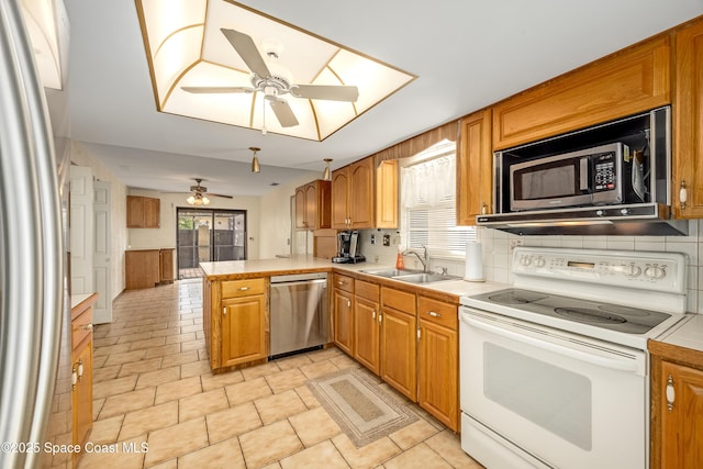 kitchen featuring sink, ceiling fan, appliances with stainless steel finishes, backsplash, and kitchen peninsula