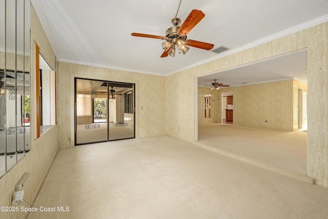 spare room with crown molding, ceiling fan, and carpet flooring