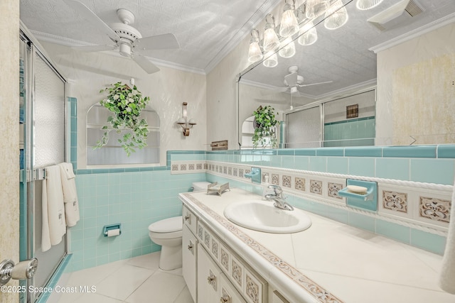 bathroom featuring a shower with door, crown molding, tile walls, and tile patterned floors